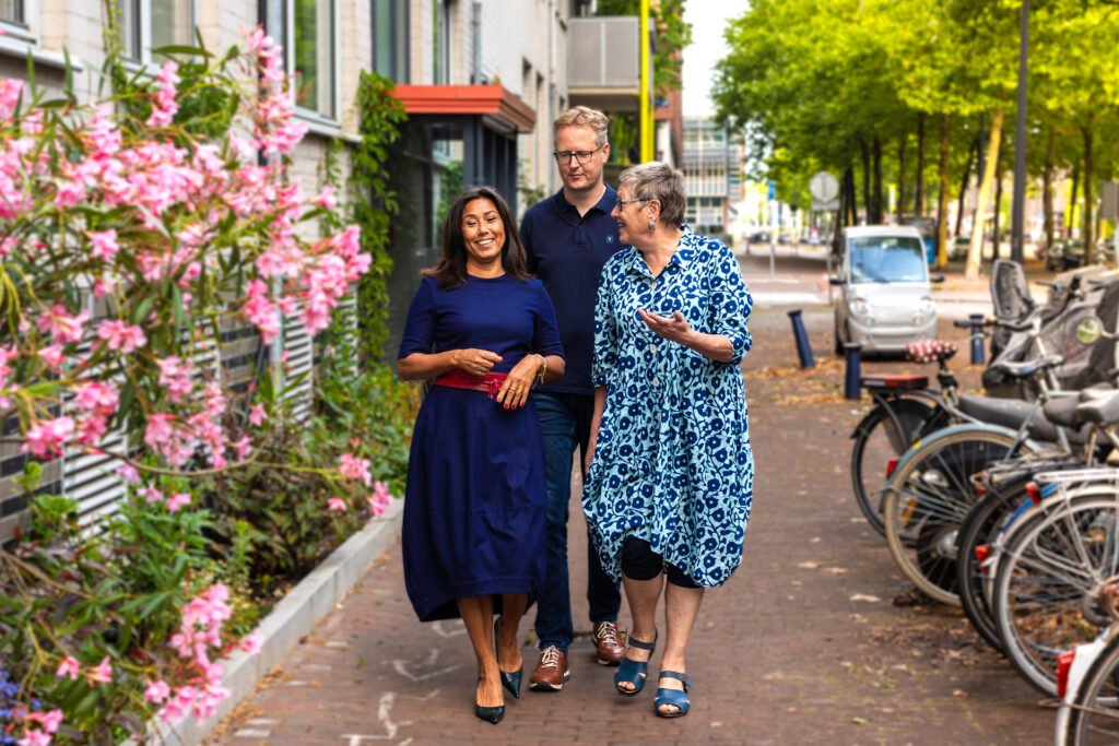 Buurtruimte De Eester, drie mensen lopen pratend door de straat in Amsterdam-Oost
