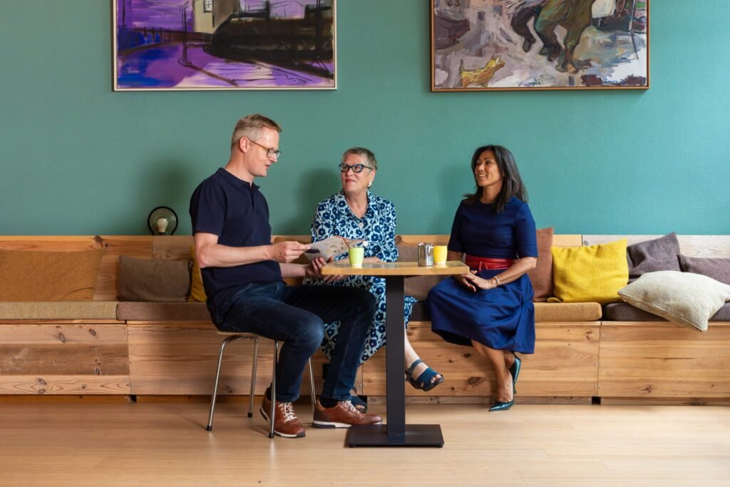 Buurtruimte De Eester, drie mensen in gesprek aan een tafel in de huiskamer